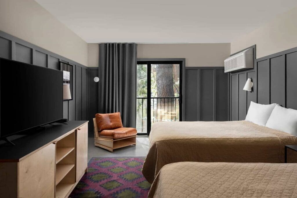 Coachman Hotel interior with queen bed and sliding glass door