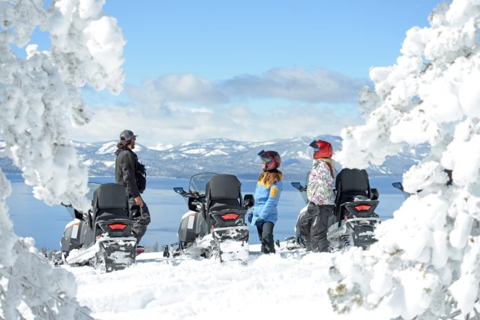 Three friends stop to admire the view in Lake Tahoe on a snowy day