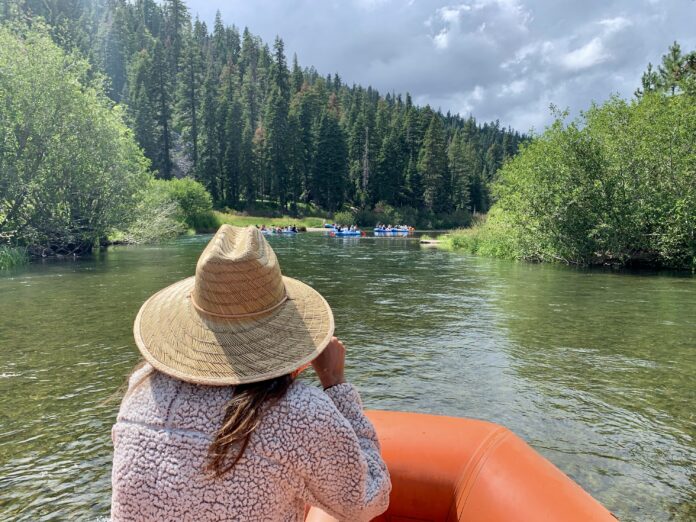 girl in a hat floating the truckee river