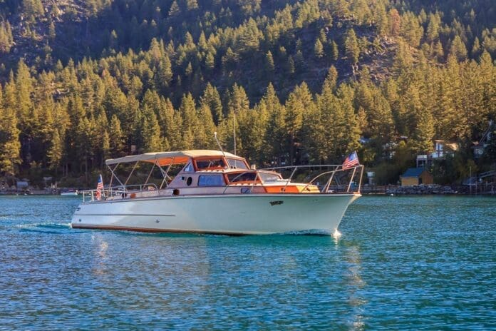 Cruise Tahoe's boat with an American flag on the bow sailing on Lake Tahoe