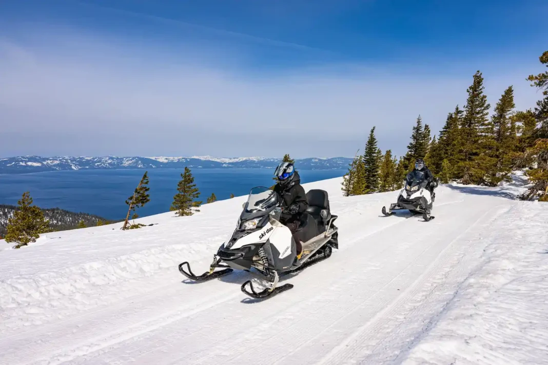 Zephyr-cove-snowmobile-tour People riding snowmobiles above Lake Tahoe