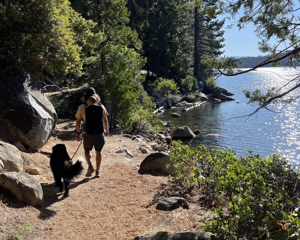 Man with dog and baby hiking around Emerald Bay on the Rubicon Trail
