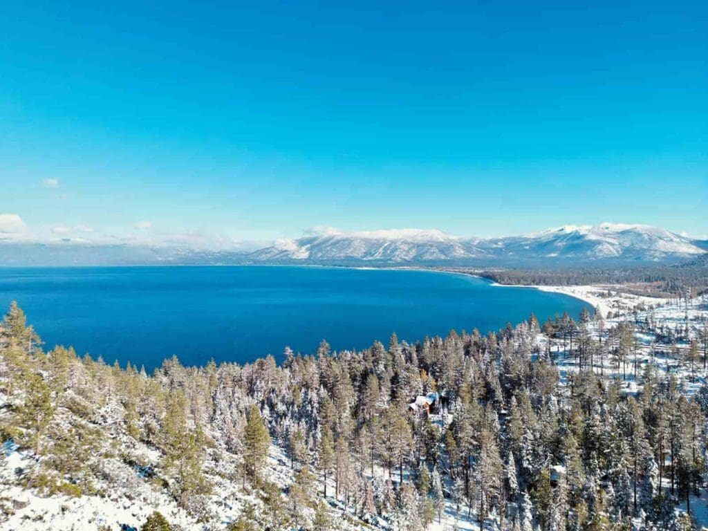 Lake Tahoe with clear blue skies on a sunny winter day with snow on the landscape